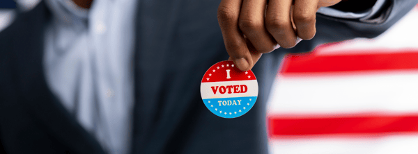 Man holding an 'I voted' sticker